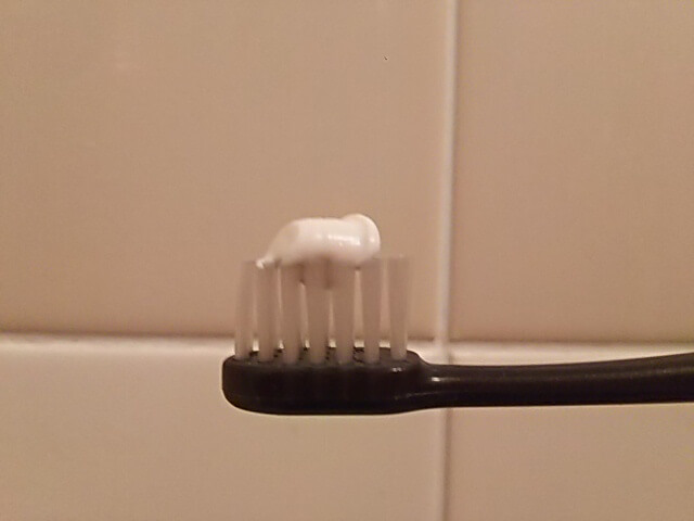 お風呂掃除で使える研磨剤入りの歯磨き粉が乗った歯ブラシ